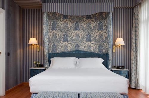 马德里阿古玛酒店的卧室配有一张白色大床和两盏灯。