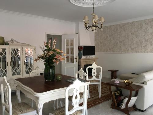 富拉多鲁Casa do gato branco的一间带桌子和白色椅子的用餐室
