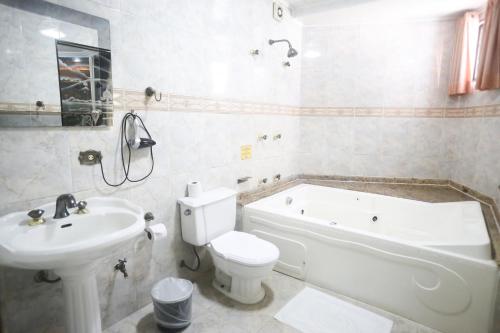 圣保罗弗洛雷斯酒店的浴室配有卫生间、浴缸和水槽。