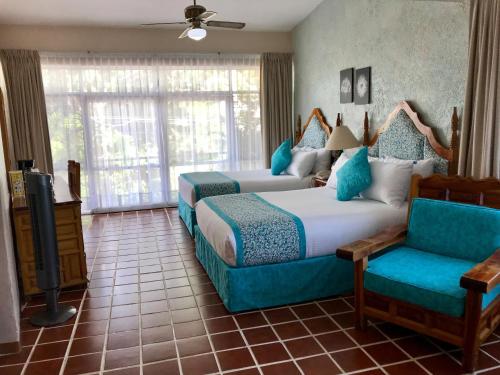 库埃纳瓦卡弗洛蕾丝花园酒店的一间带两张床、一张沙发和一台电视的卧室