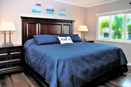 皮尔斯堡Beach Getaway - Ocean beach, tennis, golf, pool with tiki bar的一间卧室配有一张蓝色的床和两盏灯。
