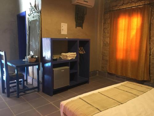 梅尔祖卡桑切斯优瑟夫酒店的一间卧室配有一张床、一张桌子和一张桌子
