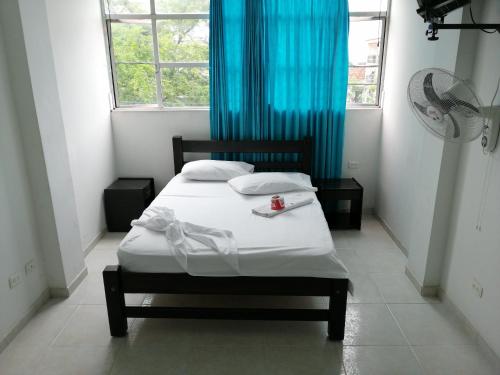 比亚维森西奥Hotel Ariari Azul的小卧室配有一张带蓝色窗帘的床