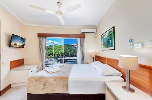 凯恩斯热带昆士兰酒店的一间卧室设有一张床和一个阳台