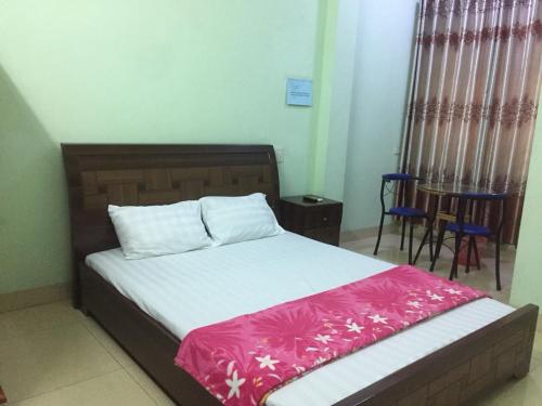 下龙湾Hân hân的一间卧室配有一张带粉色和白色毯子的床