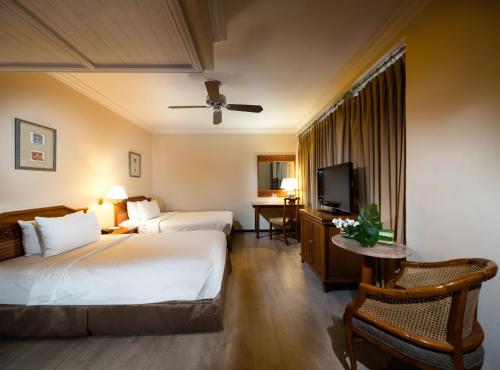 新加坡Village Hotel Albert Court by Far East Hospitality的酒店客房设有两张床和一台平面电视。