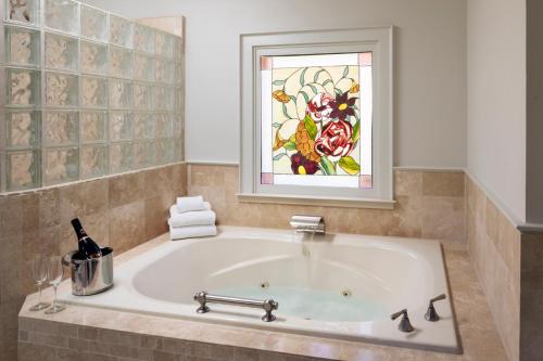 圣海伦娜Wine Country Inn Napa Valley的带浴缸的浴室,浴室设有彩色玻璃窗