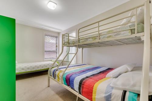 莱克斯恩特伦斯波因特度假屋的一间卧室设有两张双层床和一扇窗户。