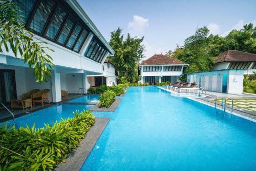 科钦Nihara Resort and Spa Cochin的大楼前的游泳池
