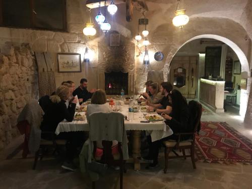 格雷梅乡村窑洞酒店的一群人坐在餐馆的桌子旁