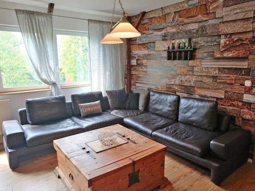 VipperowFerienhof direkt an der Mueritz SEE 10030的客厅设有真皮沙发和砖墙
