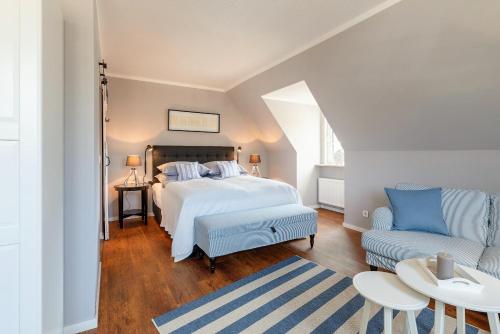 BreklumFriesen-Lodge Apartments的一间卧室配有一张床和一张沙发