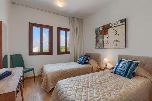 库克里亚Aphrodite Hills Rentals - Premium Serviced Apartments的客房设有两张床、一张书桌和窗户。