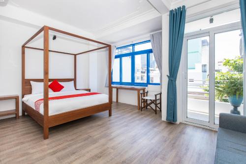 芽庄GIS Hotel Nha Trang的一间卧室配有一张天蓬床和一张书桌