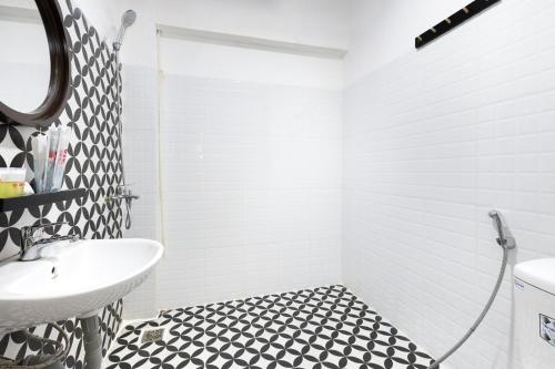 芽庄GIS Hotel Nha Trang的浴室铺有黑白瓷砖地板,配有白色水槽。