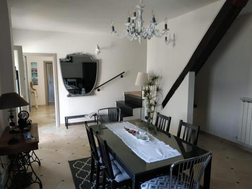莫内利亚Villa Venino的一间带桌椅和吊灯的用餐室