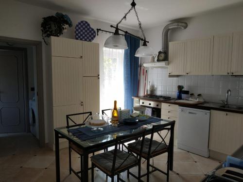 莫内利亚Villa Venino的厨房配有桌子、椅子和桌子,厨房