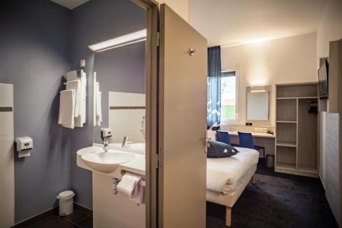 圣萨蒂南Ace Hôtel Le Mans的一间带水槽的浴室和一张位于客房内的床