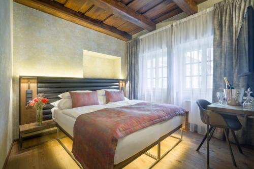 布拉格瓦尔德施泰因酒店的一间卧室配有一张床、一张书桌和一个窗户。