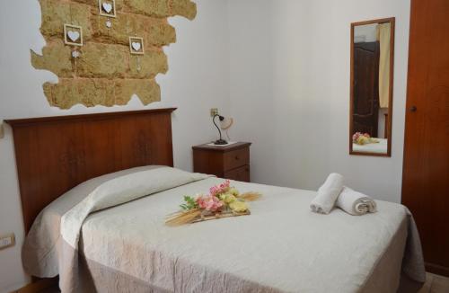 陶里萨诺Masseria Grande的一间卧室,床上放着鲜花