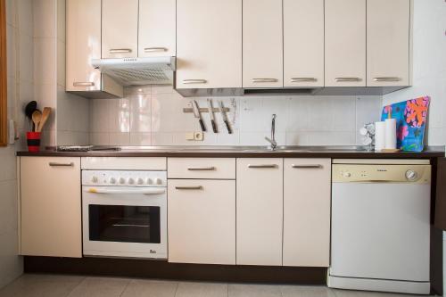 阿维拉VUT夫鲁塔广场公寓的厨房配有白色橱柜、水槽和炉灶。
