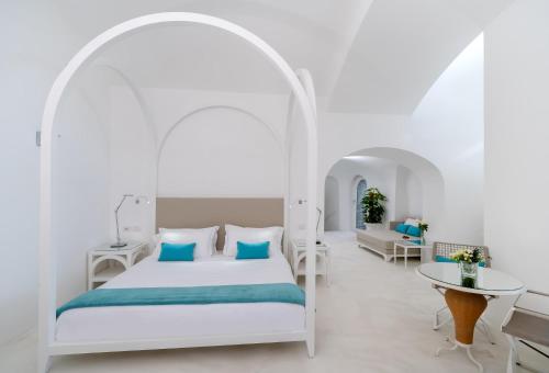索伦托贝尔维塞林纳酒店的白色卧室配有床和桌子