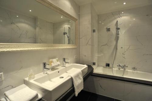赫尔蒙德卢本消夫住宿加早餐旅馆的一间带水槽、浴缸和镜子的浴室