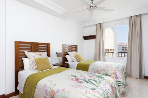 阿雷西费Rooms & Suites Balcony 3C的一间卧室设有两张床和窗户。