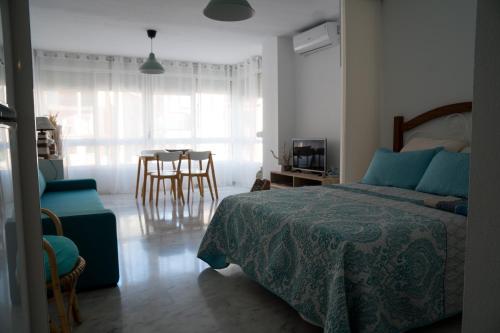 托罗克斯Apartamento Punta de Torrox的卧室配有一张床和一张桌子及椅子