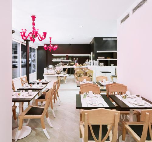 巴黎贝斯特韦斯特高级郊区88酒店的用餐室配有木桌和椅子