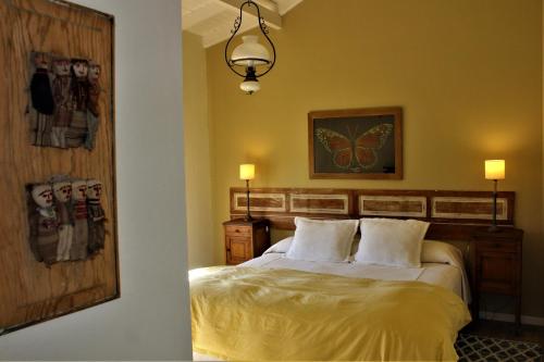 本塔纳山村Casa Retama Boutique的卧室配有一张床,墙上挂着一幅画