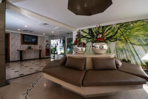瓜达拉哈拉Hotel Ronda Minerva的带沙发和壁画的客厅