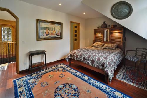 翁弗勒尔穆加多尔公寓的一间卧室配有一张床和地毯