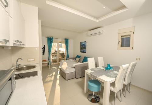 蒂瓦特Sea Point Apart hotel Tivat的厨房以及带桌子和沙发的客厅。