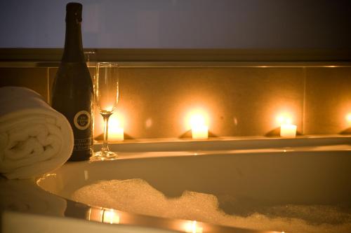 纳皮尔皇冠大酒店的浴缸内的一瓶香槟和蜡烛