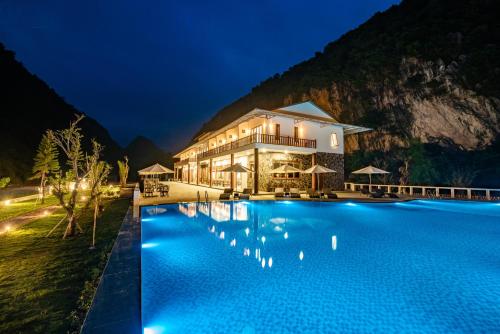 枚州县Mai Chau Mountain View Resort的夜间带游泳池的度假村