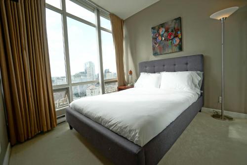 温哥华杜诺文酒店的一间卧室设有一张大床和大窗户