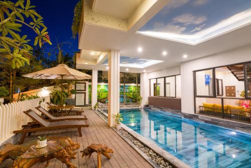会安Hoi An Grace River Villa的一座带庭院和房子的别墅内的游泳池