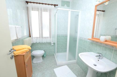 乌马格Apartments Ederina的浴室配有卫生间、盥洗盆和淋浴。