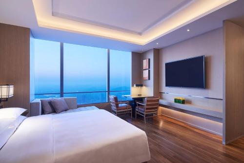 徐州徐州苏宁凯悦酒店的一间酒店客房,配有一张大床和一台平面电视
