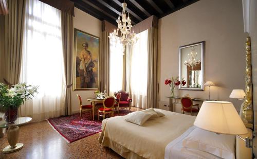 威尼斯利亚斯迪皇宫酒店的卧室配有一张床和一张桌子及椅子