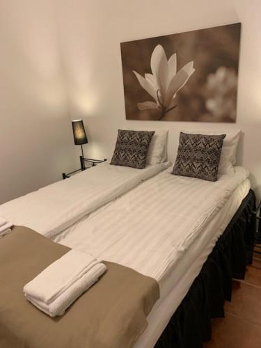 易克略Mälarö Hotell的两张带白色床单和枕头的床。