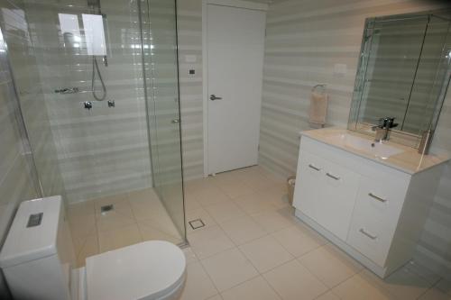 LeetonKindred Lodge Apartments的带淋浴、卫生间和盥洗盆的浴室