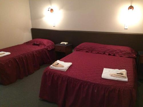 菲尔丁Feilding Hotel的两张位于酒店客房的床,配有毛巾