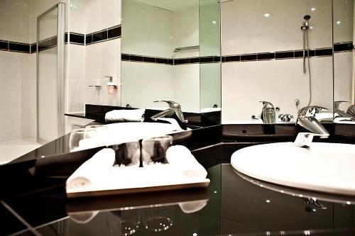 施瓦岑费尔德施彻沃赞菲尔德施洛斯酒店的浴室设有2个水槽和镜子
