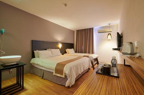 阿罗士打The Leverage Lite Hotel - Kuala Kedah的酒店客房设有两张床和盥洗盆