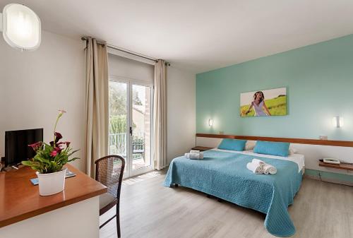 斯哥利提I Giardini di Athena- Athena Resort的一间卧室配有一张床、一张书桌和一个窗户。