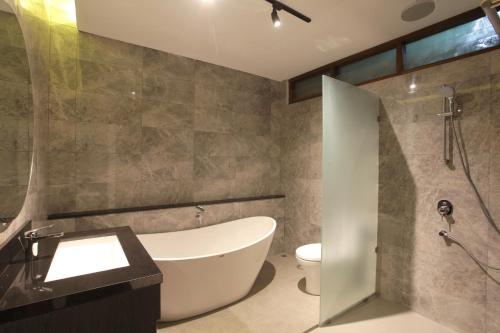 勒吉安玛塔哈利小屋酒店的带浴缸、卫生间和盥洗盆的浴室