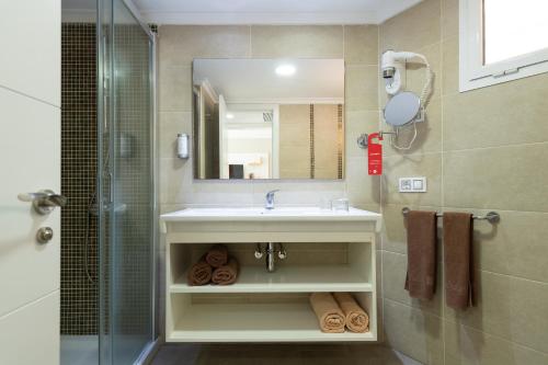 阿马多雷斯阿马多雷斯韦斯特公寓式酒店的一间带水槽、镜子和淋浴的浴室