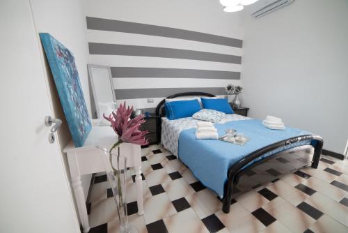 佩斯基奇Peschici HOME FILOCCO stanza e bagno privato的一间卧室设有一张蓝色的床,铺有 ⁇ 格地板